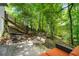 Backyard features a staircase to deck and patio with comfortable seating nestled in a lush, green setting at 4290 Inverness Ne Ct, Roswell, GA 30075