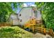 Multi-level house with a fenced yard, deck with outdoor seating, and lush green surroundings at 4290 Inverness Ne Ct, Roswell, GA 30075