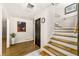 Entrance foyer featuring hardwood floors, a staircase, decorative artwork, and elegant lighting at 4290 Inverness Ne Ct, Roswell, GA 30075