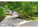 Inviting home featuring a large front yard, driveway, two-car garage, and a charming deck area perfect for enjoying the outdoors at 4290 Inverness Ne Ct, Roswell, GA 30075