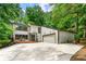 Stylish two-story home showcasing a spacious driveway and a two-car garage complemented by lush trees in the background at 4290 Inverness Ne Ct, Roswell, GA 30075
