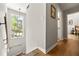 Bright hallway with wood floors, a window view, and access to rooms, creating an inviting and functional space at 4290 Inverness Ne Ct, Roswell, GA 30075