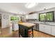 Well-lit kitchen featuring granite countertops, center island, and a window overlooking a backyard at 4290 Inverness Ne Ct, Roswell, GA 30075