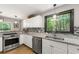 Spacious kitchen with white cabinets, granite countertops, stainless steel appliances, and nature views at 4290 Inverness Ne Ct, Roswell, GA 30075