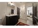 Stylish bathroom with dark wood cabinets, marble countertops and a tiled shower and a door leading to the bedroom at 633 Channing Nw Dr, Atlanta, GA 30318