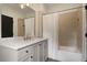 Well-lit bathroom featuring white cabinets with a white marble countertop and a tub with a shower and a tile surround at 633 Channing Nw Dr, Atlanta, GA 30318