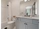 Bright bathroom featuring a tub with a shower, a white cabinet and granite countertops and a hexagon patterned floor at 633 Channing Nw Dr, Atlanta, GA 30318