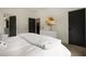 Bedroom featuring a large bed, a white dresser with gold mirror, and dark doors providing a contrasting modern style at 633 Channing Nw Dr, Atlanta, GA 30318