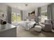 Bright bedroom with two large windows, a white bed with soft textures, and a comfortable chair next to a soft stool at 633 Channing Nw Dr, Atlanta, GA 30318
