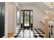 Inviting entryway features black and white tile, a black framed door, and stairs at 633 Channing Nw Dr, Atlanta, GA 30318