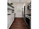 Galley kitchen features white cabinets, stainless steel appliances, and floating shelves at 633 Channing Nw Dr, Atlanta, GA 30318