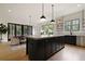 Open kitchen with black cabinets, an island, and stainless steel appliances flowing to the dining room at 633 Channing Nw Dr, Atlanta, GA 30318