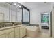 The bathroom features double vanity sinks, an oval bathtub, a window with shutters, and tile flooring at 3467 Brookleigh Ne Ln, Atlanta, GA 30319