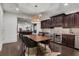 Dining area featuring dark wood cabinets with a wine cooler, stylish lighting, and a view into the game room at 3467 Brookleigh Ne Ln, Atlanta, GA 30319