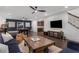 Large game room with sleek ceiling fans, comfortable seating, and entertainment, adjacent to a staircase and kitchen at 3467 Brookleigh Ne Ln, Atlanta, GA 30319