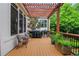 Outdoor patio featuring grilling area, wood trellis, string lights, wood flooring, seating, and landscaping at 3467 Brookleigh Ne Ln, Atlanta, GA 30319