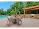 Poolside patio with shaded pergola, stone accents, and barbecue area, perfect for outdoor gatherings at 3467 Brookleigh Ne Ln, Atlanta, GA 30319
