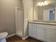 Bathroom featuring granite counters, white cabinets, shower, and wood-look floors at 400 Old Stagecoach Rd, Carrollton, GA 30116