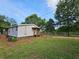 Exterior view of home with covered porch surrounded by lush green grass and mature trees at 400 Old Stagecoach Rd, Carrollton, GA 30116