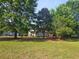 Spacious front lawn with mature trees surrounds this cozy home with charming covered porch at 400 Old Stagecoach Rd, Carrollton, GA 30116
