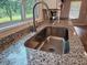 Close-up of a granite countertop and stainless steel sink with natural light from a window at 400 Old Stagecoach Rd, Carrollton, GA 30116