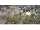 Aerial view showcasing a home's green metal roof nestled in a serene, wooded area with mature trees at 5642 N Highway 212, Covington, GA 30016