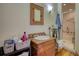 A vintage bathroom with hardwood floors, a wooden sink, a walk-in shower, and a small vanity at 5642 N Highway 212, Covington, GA 30016