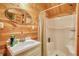 Bathroom featuring wood walls, a white vanity, and a walk-in shower with clear glass doors at 5642 N Highway 212, Covington, GA 30016