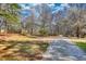 Expansive front yard with driveway and mature trees at 5642 N Highway 212, Covington, GA 30016