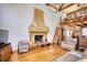 A unique living room featuring high ceilings, wooden beams, a stone fireplace, and hardwood floors at 5642 N Highway 212, Covington, GA 30016