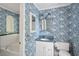 Charming bathroom with blue wallpaper, white vanity and blue granite countertop, with a soaking tub and decorative sconces at 22 Peachtree Hills Ne Ave, Atlanta, GA 30305