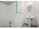 Vintage bathroom featuring white tiles with green trim, pedestal sink and patterned floor at 22 Peachtree Hills Ne Ave, Atlanta, GA 30305