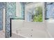 Bright bathroom features a white tub, white tile with dark trim, and a window with outdoor views at 22 Peachtree Hills Ne Ave, Atlanta, GA 30305