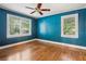 Sunny blue bedroom showcasing hardwood floors and two bright windows bringing in natural light at 22 Peachtree Hills Ne Ave, Atlanta, GA 30305