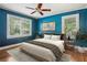 Bright blue bedroom with a ceiling fan, hardwood floors, area rug, and two bright windows at 22 Peachtree Hills Ne Ave, Atlanta, GA 30305