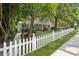 View of a home with a white picket fence, lush landscaping, and a sidewalk leading to the entrance at 22 Peachtree Hills Ne Ave, Atlanta, GA 30305