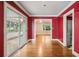 Hallway with hardwood floors, red walls, and doorways leading to a living room and another room at 22 Peachtree Hills Ne Ave, Atlanta, GA 30305