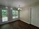 Dining room with wood flooring, a modern chandelier, and a door leading to the backyard at 312 Yarbrough Ct, Dacula, GA 30019