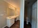 Bright main bathroom featuring a double sink vanity, a large mirror, and a separate toilet area at 312 Yarbrough Ct, Dacula, GA 30019