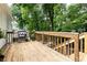 Spacious wood back deck with grill, wood railings, and mature trees at 495 Hascall Nw Rd, Atlanta, GA 30309