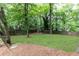 Expansive backyard with green grass, mature trees, and wooden fence at 495 Hascall Nw Rd, Atlanta, GA 30309