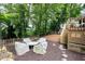 Backyard patio with outdoor seating, stairs to deck, and lush landscaping at 495 Hascall Nw Rd, Atlanta, GA 30309
