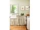 Bright kitchen with a farmhouse sink, elegant fixtures, and custom striped valance, complemented by sage green walls at 495 Hascall Nw Rd, Atlanta, GA 30309