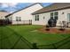 Landscaped backyard with black fencing, patio, seating, and a grill for outdoor enjoyment at 513 Forest Ln, Canton, GA 30114