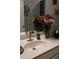 A vanity sink with flowers and butterfly wall decorations, adding a touch of nature at 513 Forest Ln, Canton, GA 30114