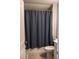 Bathroom features a neutral shower curtain, toilet, and tiled flooring at 513 Forest Ln, Canton, GA 30114