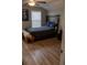Bedroom with hardwood floors, window with blinds, and a dark-colored bed frame at 513 Forest Ln, Canton, GA 30114