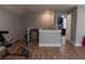 Open-concept bonus room featuring an exercise bike, a mini-fridge, and a peek into the bedroom at 513 Forest Ln, Canton, GA 30114