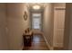 Hallway with wood floors, neutral paint, coat closet, and decorative table at 513 Forest Ln, Canton, GA 30114