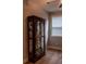 Display cabinet with glass shelves for showcasing collectibles and natural light from window with blinds at 513 Forest Ln, Canton, GA 30114